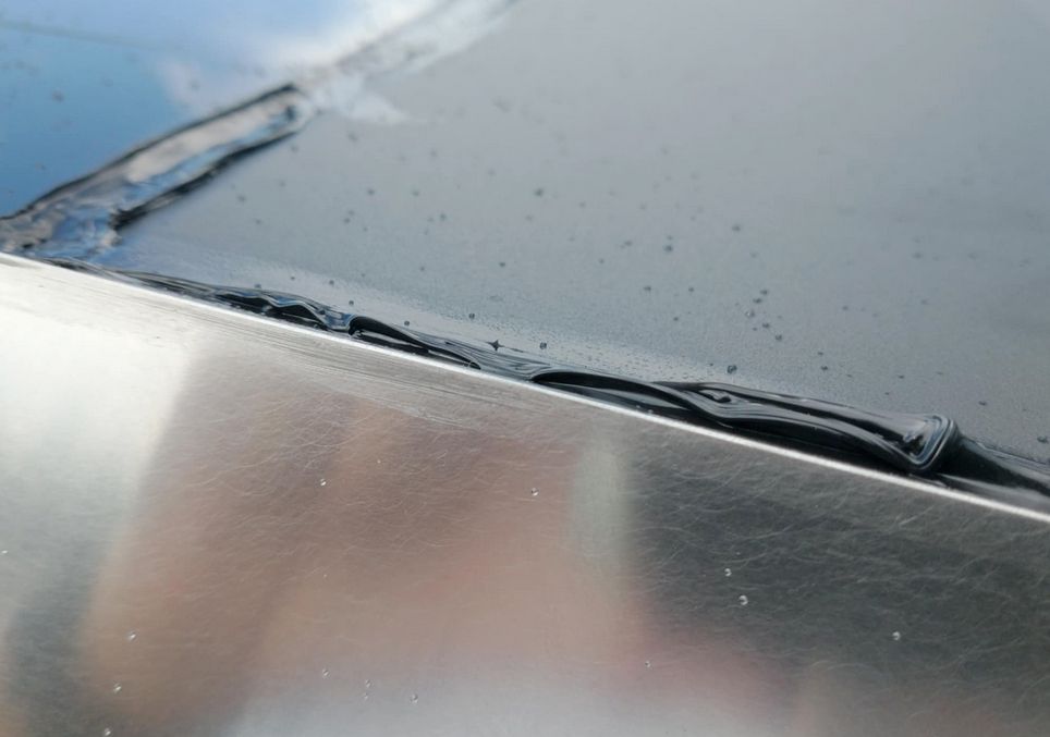 another picture showing very unevenly applied black silicone along a different seam of the car