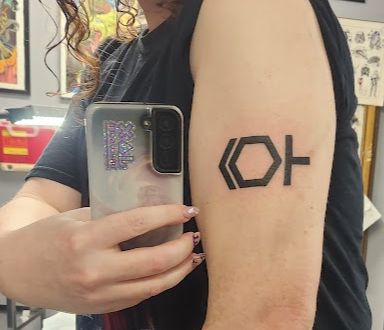 An upper arm with an ISO symbol which combines both the male and female symbols.