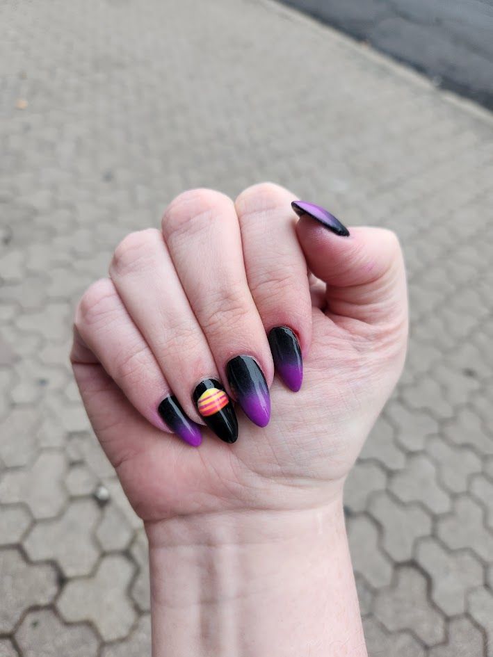 Sìne's nails; they have a black-to-purple gradient. The ring finger has a synthwave-style setting sun.