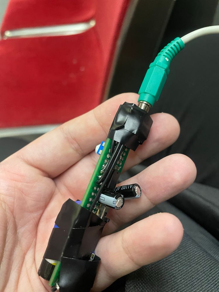 Circuit board with two audio cables, electrical tape, IC and capacitors