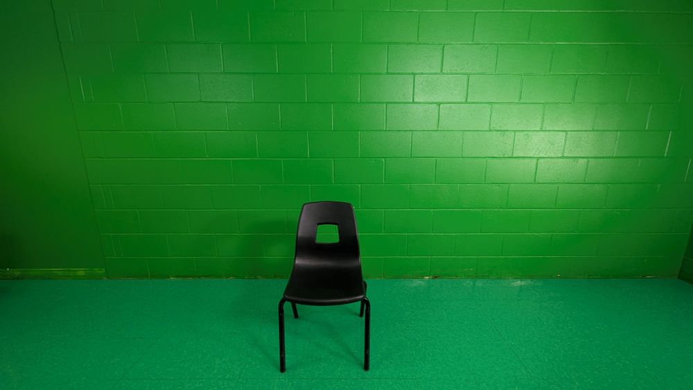 A black chair on a green background 