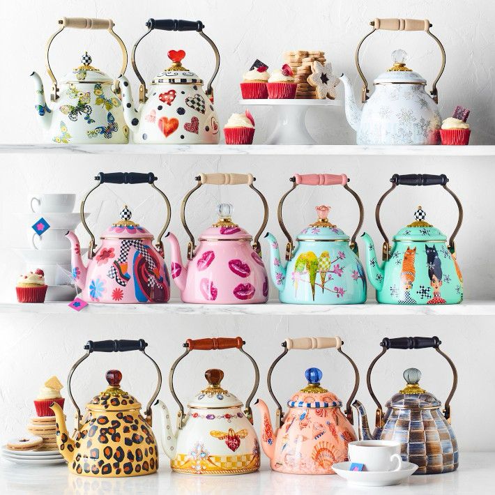 11 teapots. The first one is white with blue, green, and yellow butterflies with a black and white checkered knob and white handle. The second is white with red hearts and black and white checkered hearts, and it’s a red heart knob and a black handle. The third is white with very pale blue snowflakes and a round white knob and beige handle. The fourth is pink with darker pink and blue flowers as well as a leg with black and white checked tights and colorful shoes, with a black and white checkered knob and a black handle. The fifth is the same color pink but with dark pink kisses, a white knob, and a beige handle. The sixth is light blue with green and yellow birds perched on a branch, with a light pink flower-shaped knob and handle. The seventh is teal with an orange cat and a black cat, a checkered knob, and a black handle. The eighth is cheetah patterned with a dark brown knob and black handle. The ninth is cream colored with a yellow and brown bee and a yellow checkered pattern on the bottom, with little gems around the top and a dark brown knob and lighter brown handle. The tenth is salmon colored with pink seashells all around it, with a blue checkered rim, a dark blue knob, and a white handle. The eleventh is dark, metallic brown and blue checkered with a grayish-blue knob and a black handle.