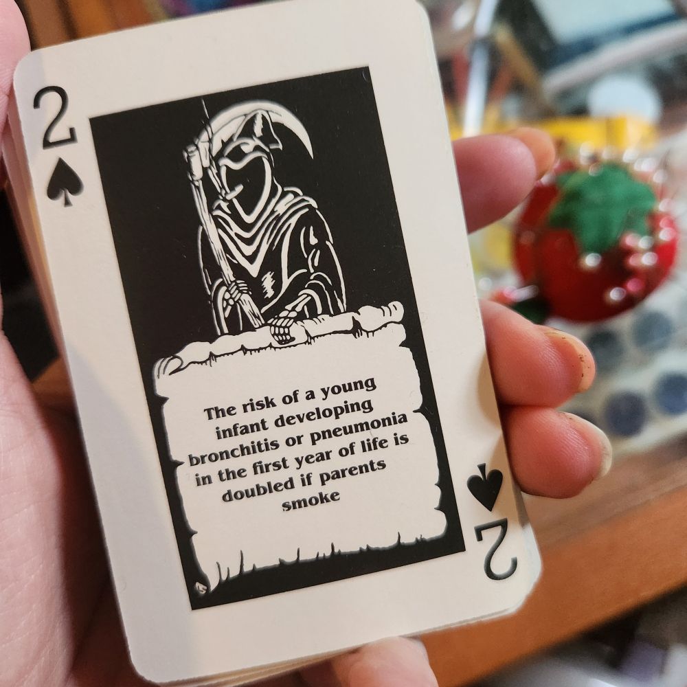 2 of spades with a grim reaper and text: the risk of a young infant developing bronchitis or pneumonia in the first year of life is doubled if parents smoke
