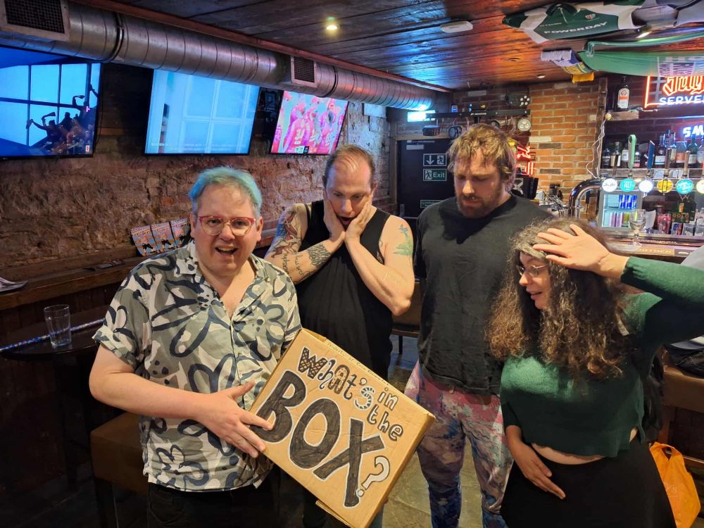Friz Frizzle, Beth Rose, Jacob Henegan and Chrissy Derbyshire  pose around a box