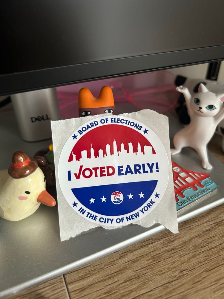 Image of an "I voted early!" sticker on a desk, surrounded by little animal figurines  