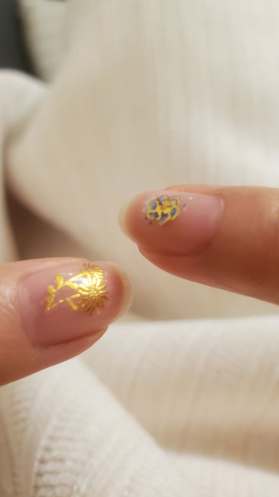 Two of my fingers 
One with a gold flower sticker & one with a blue & gold flower sticker 