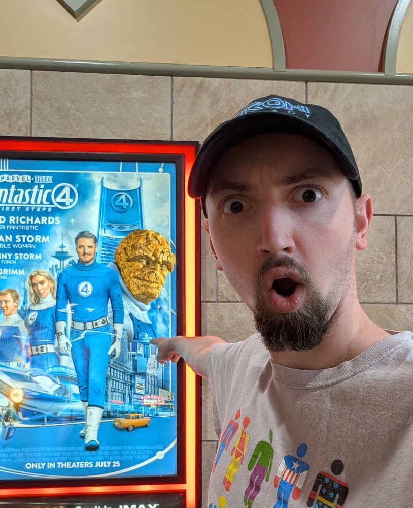 A picture of OtterlyNoah standing in front of a film poster for the movie Fantastic Four First Steps which is currently out in theaters and distributed by Marvel and Disney 