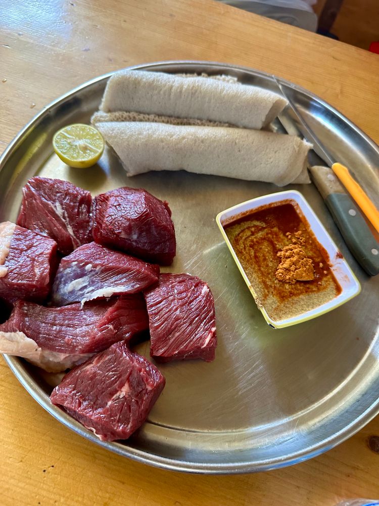 Chunks of raw beef Ethiopian style with injera and sauce