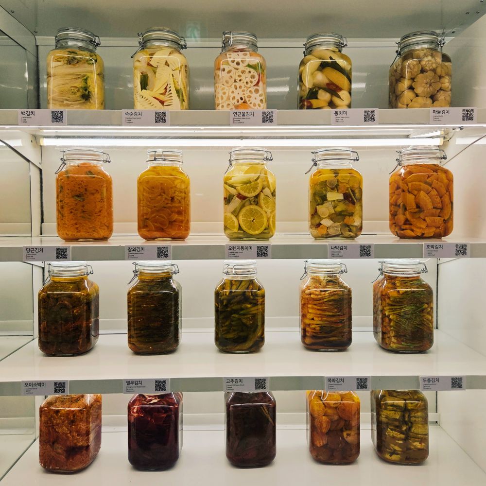 Rows of pickled vegetables on white shelves