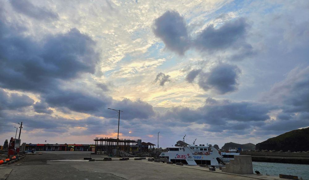 A break in the clouds near sunset over concrete wharf and