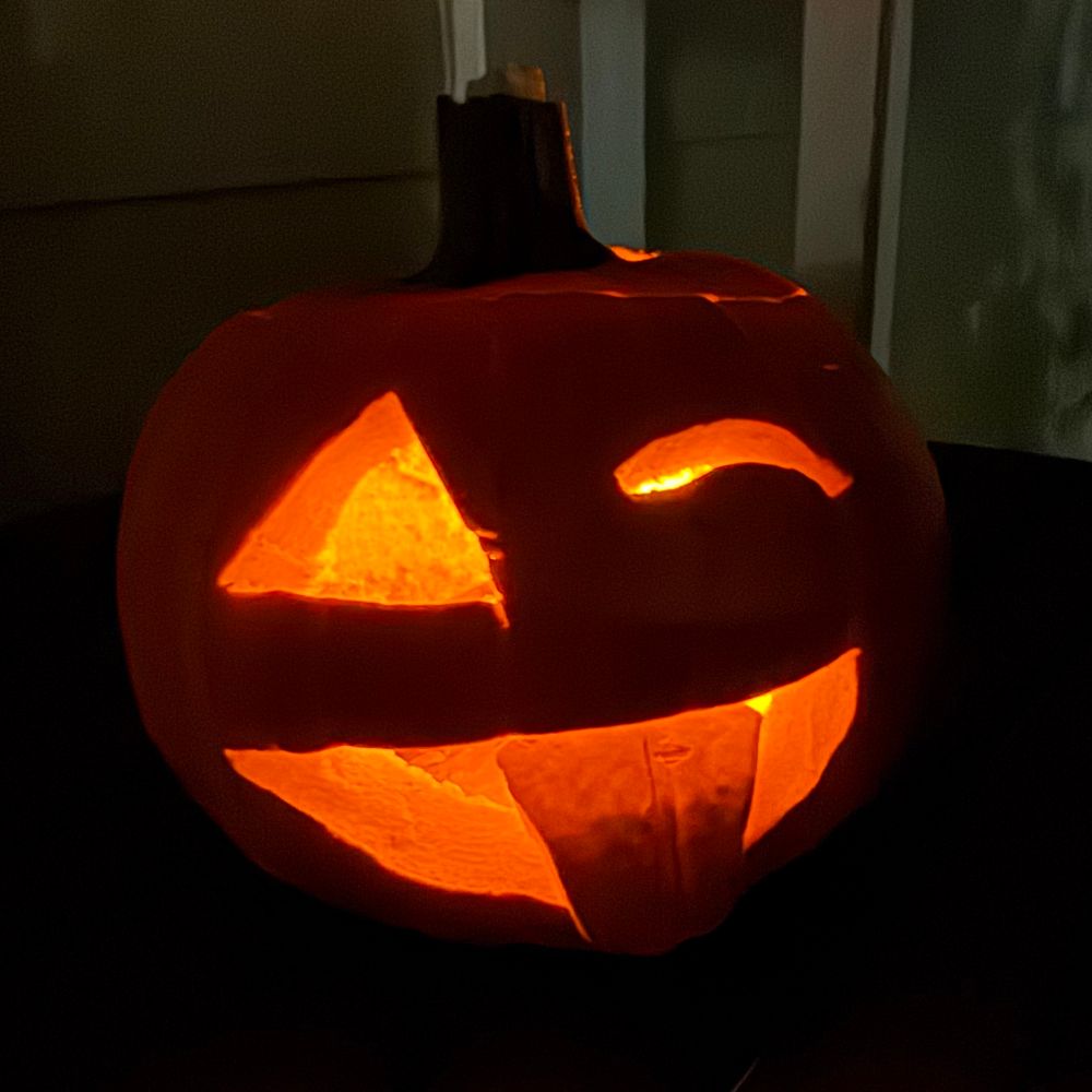 A Jack-o-lantern with one eye closed and sticking his tongue out