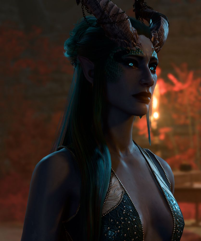 Ki’Zarra bust photo in her teal sleeveless dress with some interesting contrast due to red leaves in the background
