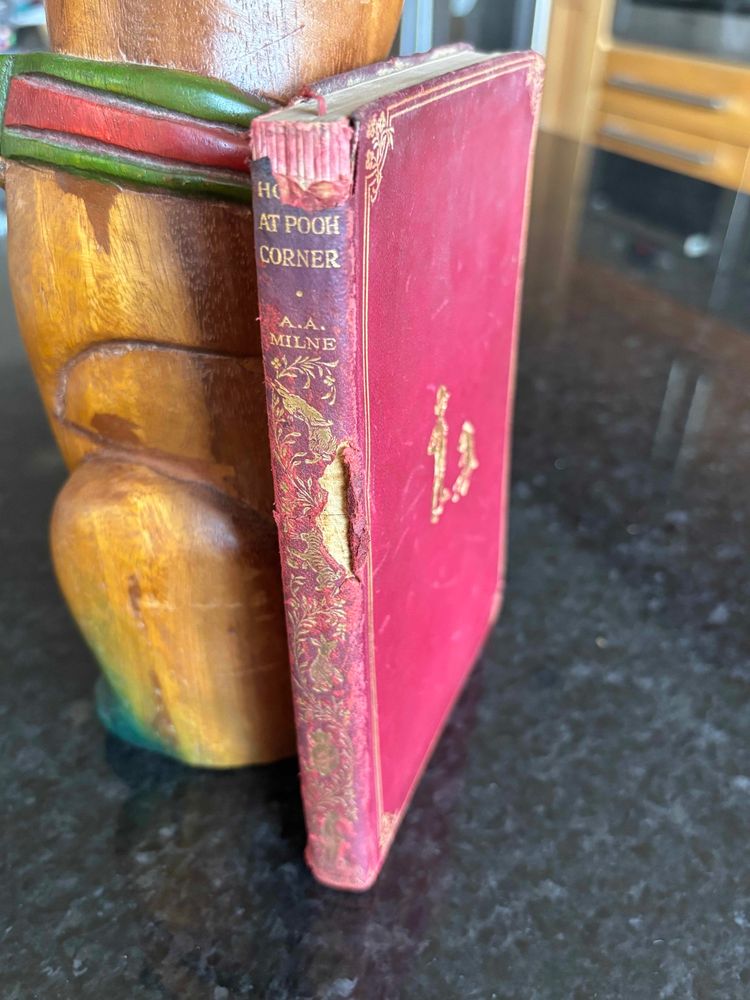 A 1925 red leather bound edition of House at Pooh Corner by A. A. Milne. A little torn and worn but so would we all be at 100 years old!