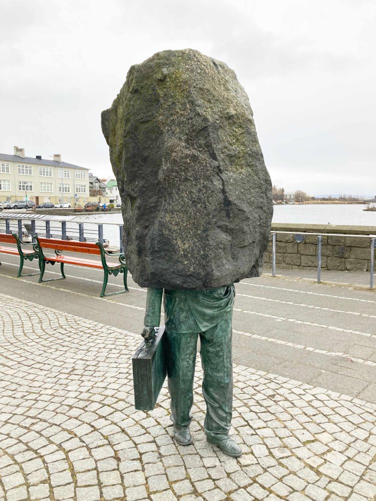 Sculpture that seems only half-finished. Bottom half is of a man carrying a briefcase. Top half is a large block of basalt. This is the Monument to the Unknown Bureaucrat in Reykjavik, created by sculptor Magnus Tomasson. (Pic Roger P. Heath)
