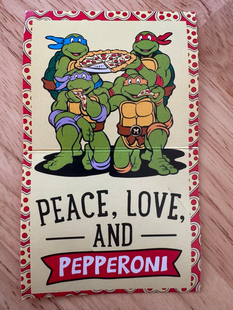 A valentine with the Teenage Mutant Ninja Turtles enjoying pizza above the text “peace, love, and pepperoni.”
