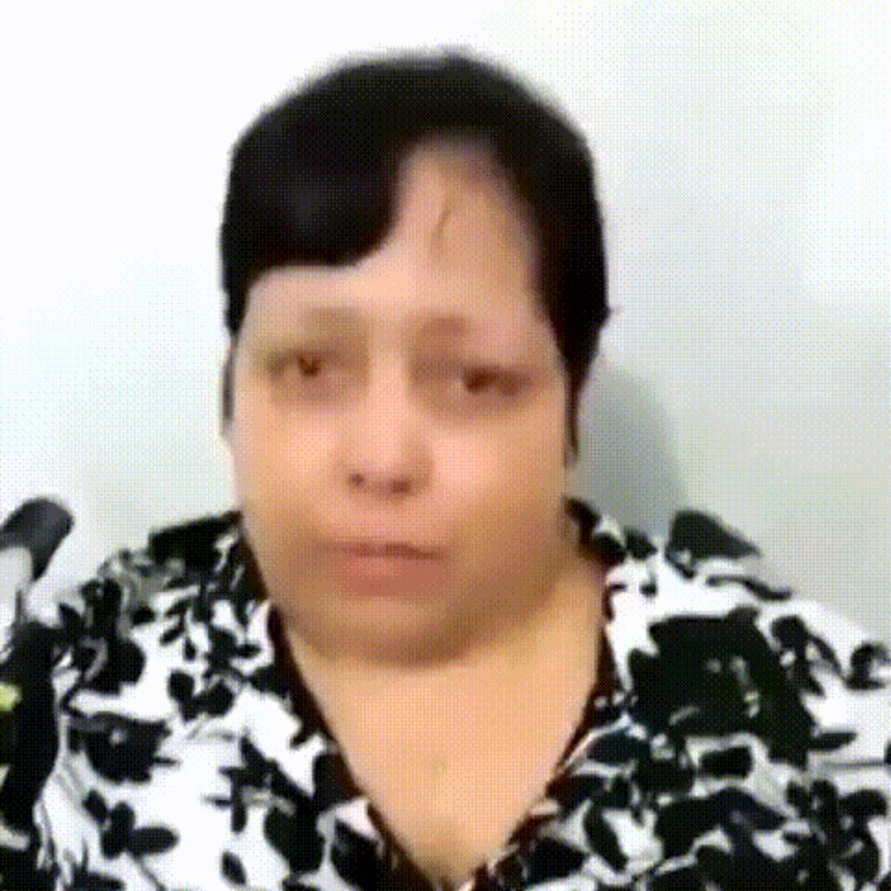 a close up of a woman 's face with a black and white floral shirt .