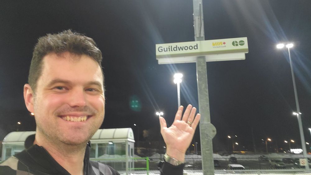 Yesterday: standing in front of the Guildwood GO/VIA train sign on the platform and pointing to it. 