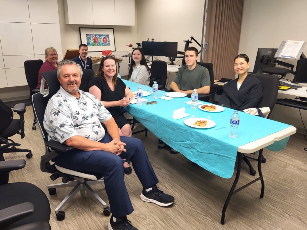 Nate and Lunch and Learn attendees sit at the table in our Solutions lab.