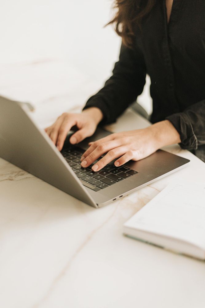 A woman types on a laptop.