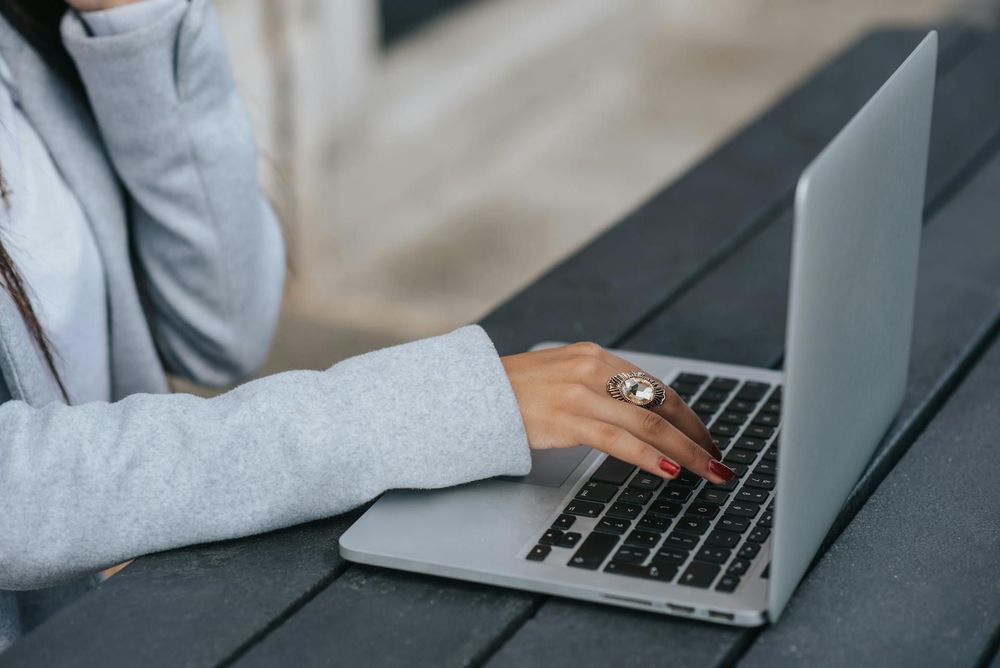 A woman types on a laptop.