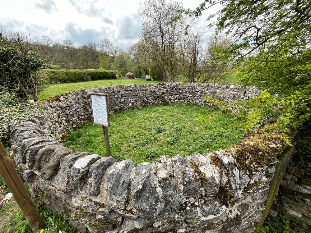 Hope Pinfold, a stone structure. Pinfold is derived from the Saxon Old English pundfald meaning an enclosure & the term was used largely in the north & east of the country. These enclosures were used specifically to house stray cattle or sheep which had wandered from their owners' land or which had been found grazing on common land without common rights. These would be rounded up & kept in the pinfold until they were claimed. To retrieve the animals, a fine would have to be paid to the pinder, who was an officer of the Lord of the Manor. It was a serious offence to break your animals out of the pinfold, punishable by a further fine or imprisonment! Occasionally the pinfold might be rented as a temporary holding pen overnight by drovers on their way to market. Although they date from much earlier, it is thought that by the 16th century, almost every settlement would have had its own pinfold & pinder. Sadly, most of these have been lost over the years, but some survive almost intact whilst others have been restored.