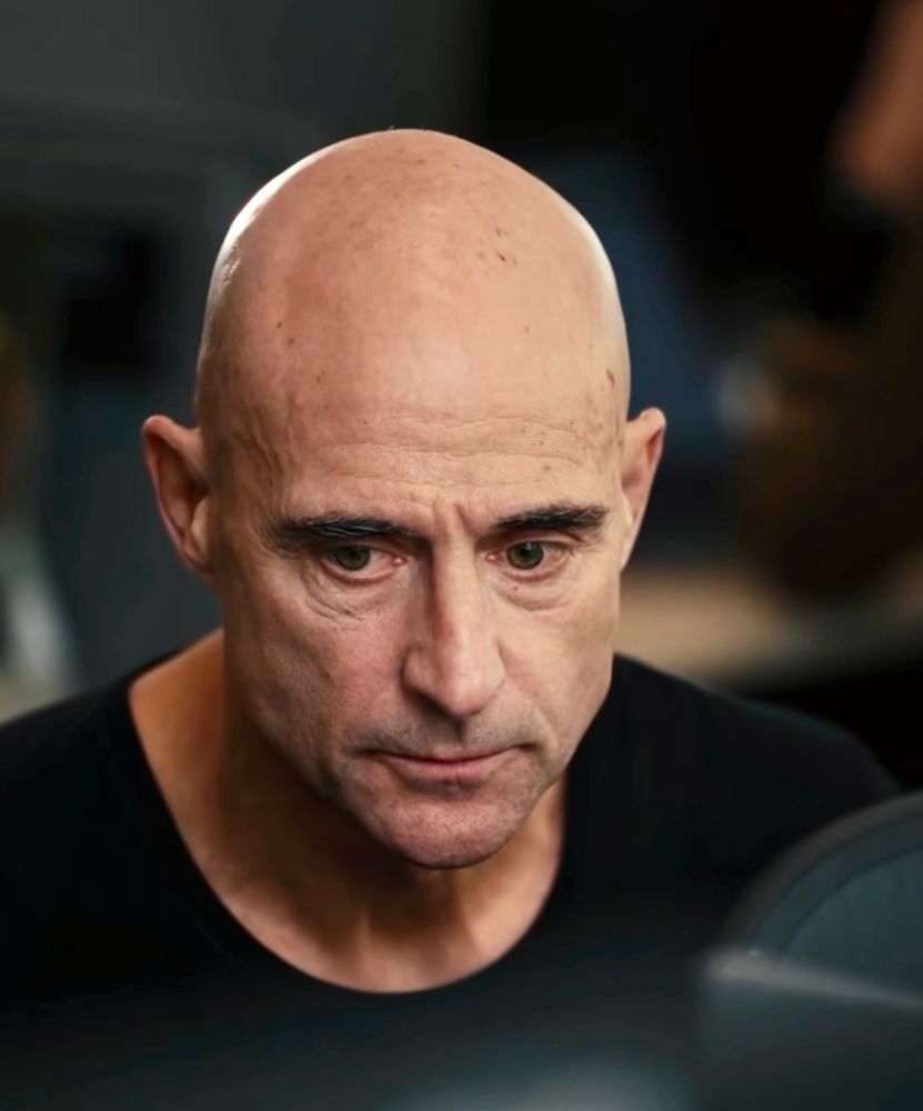 Close up of Mark Strong looking pensive 
