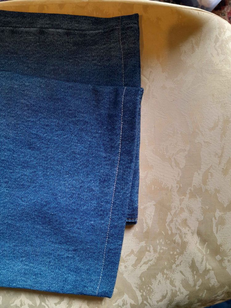 The hem on a pair of blue jeans. The thread is grey