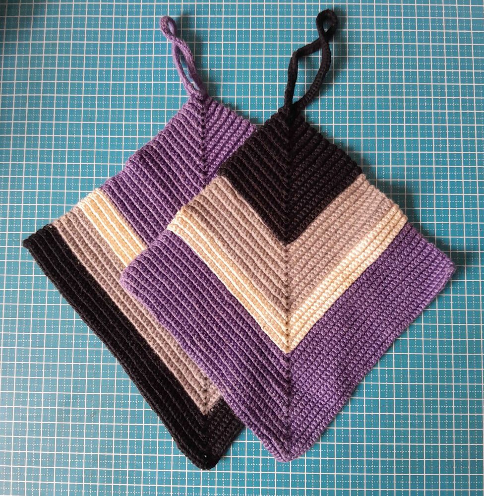 two oven cloths in the colors of the ace flag (black, grey, white and purple)
Both start with a loop for hanging them, then are worked in increasing rows of single crochet through the backloop
one starts with purple, the other one with black