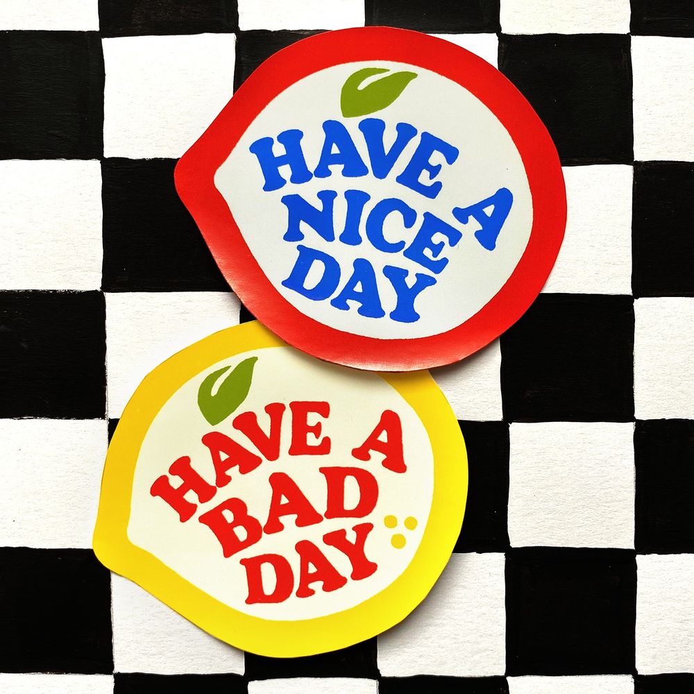 Photo of fruit label stickers. Apple says Have a nice day. Lemon says Have a bad day 