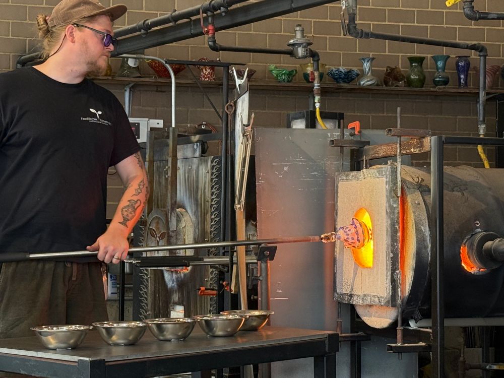A man is pulling a beautiful glass shell he made from the fire at the garden’s Hot Shop
Columbus Ohio