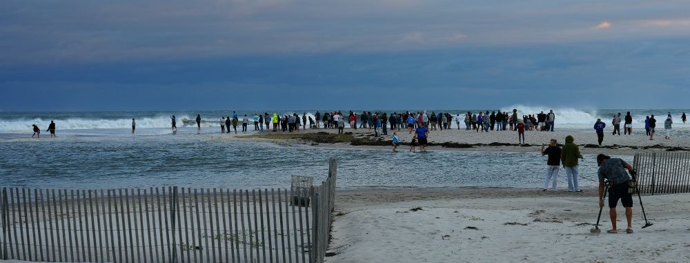 People are on sand that is higher so did not get covered in water from the Atlantic Ocean.