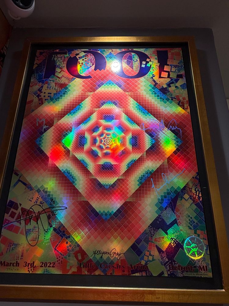 https://www.cosm.org/entheon TOOL POSTER COLLECTION Loan of Rod Rohrs and the Reach Out and Beyond Gallery The progressive metal band TOOL released their fifth studio album, Fear Inoculum on August 30, 2019. Hailed by music reviewers and fans alike, the Song /empest won a Grammy for best metal performance. For their Fear Inoculum Tour, Tool's lead guitarist and art director, Adam Jones, planned a special limited edition silkscreen poster for each of the 104 concert dates from 2019-2022. Adam invited dozens of artists to be part of the series. The posters became instant collector's items and sometimes incited near riots at venues as they sold out. Collector Rod Rohrs traveled to each venue waiting in lines for hours and many times overnight so that he could get choice and unique posters signed by the band and doodled on by Adam Jones. Many of the posters were customized later with remarques by the original artists. We are grateful to display thirty-three posters loaned from the amazing collection of Rod Rohrs in the Visionary Vine stairwell gallery of Entheon.