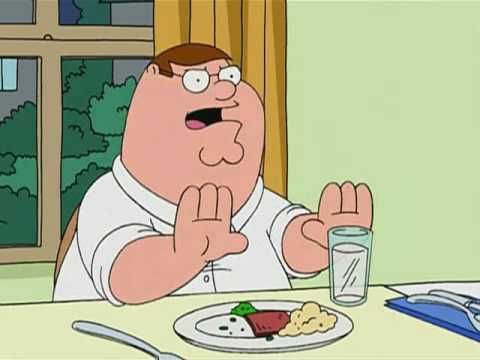 Fotograma de Padre de Familia, Peter Griffin sentado a la mesa del comedor con las manos levantadas, referencia a la frase de "este no es mi vaso de Batman".