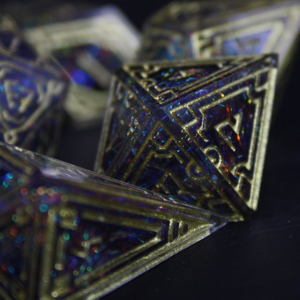 Ornate dice with a dark rainbow inside made with multicoloured fibres, gold patterns and numbers