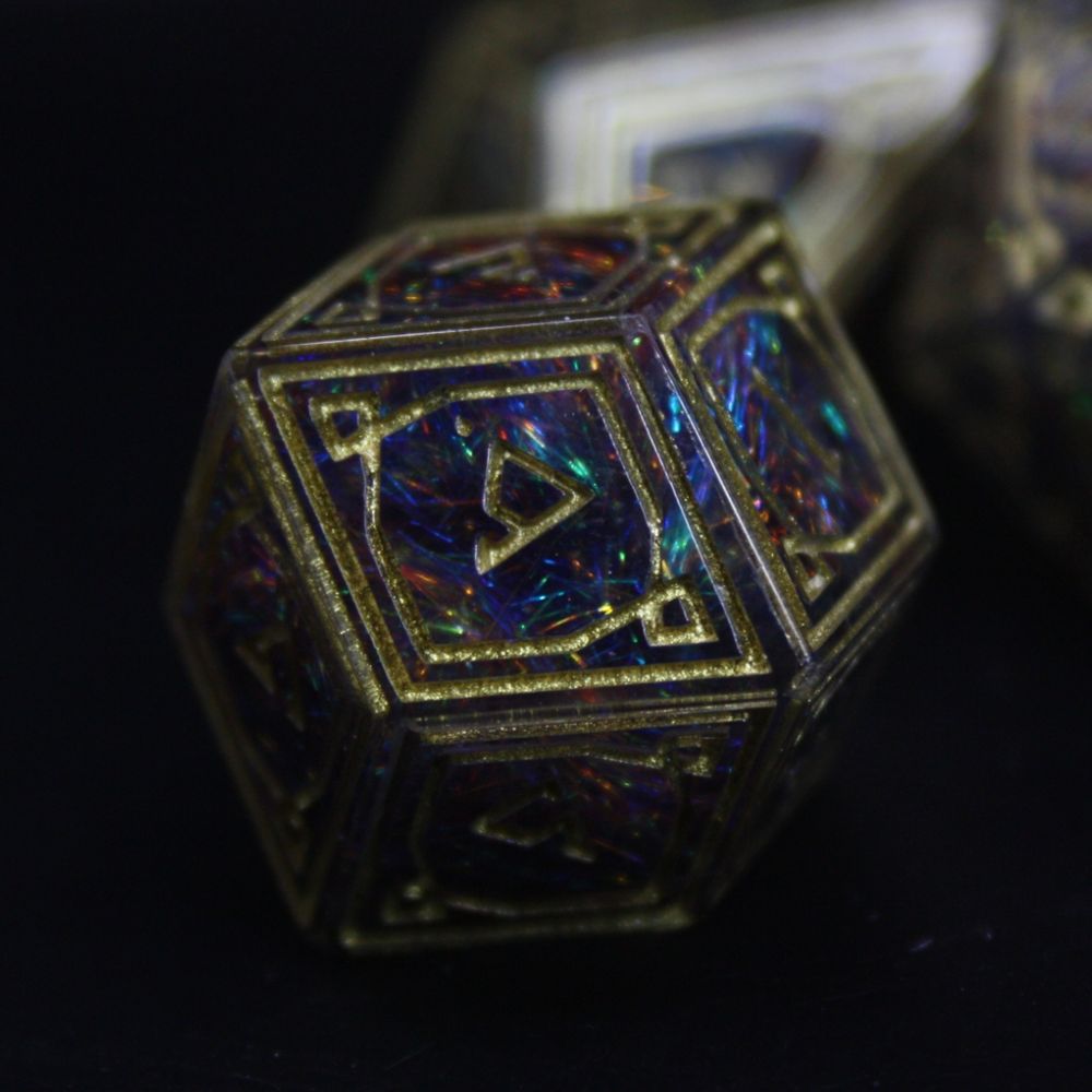 Ornate dice with a dark rainbow inside made with multicoloured fibres, gold patterns and numbers