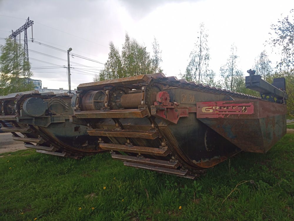 Photo of a big tractor tracks (or some such thing, I'm not sure), muddy & a bit rusty.