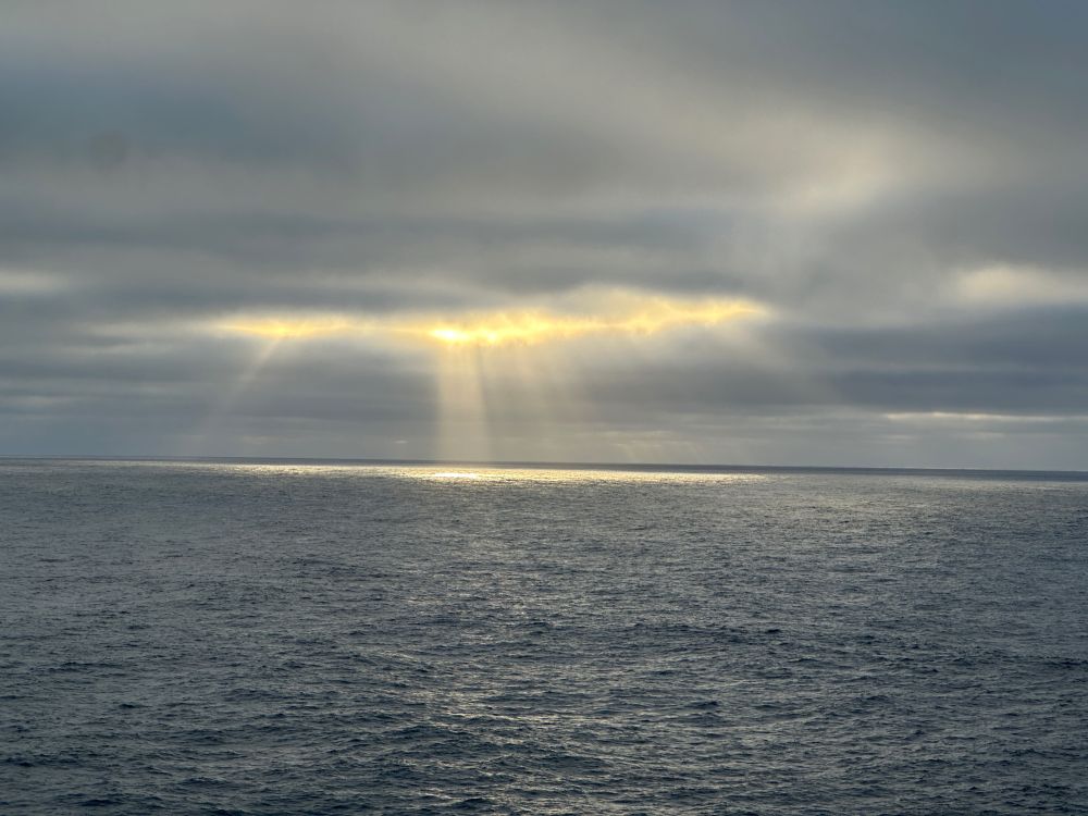 A shot of sun rays streaking through the clouds over the Atlantic Ocean.