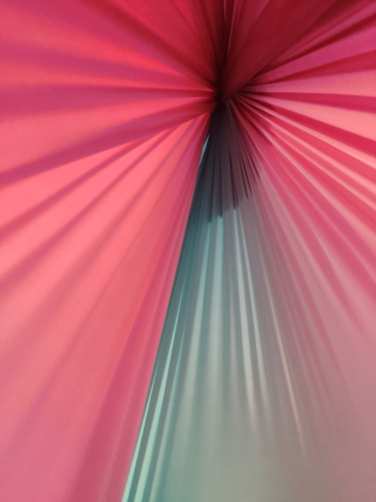 Foto aus dem inneren einer sensory swing. Zu sehen ist ein Stoff der nach oben hin zusammenläuft. Er hat einen Farbübergang von hellblau zu pink