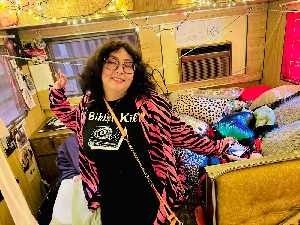 a photo of my girlfriend, a curly-haired girl in a bikini kill T and pink zebra jacket, doing a glamorous pose.