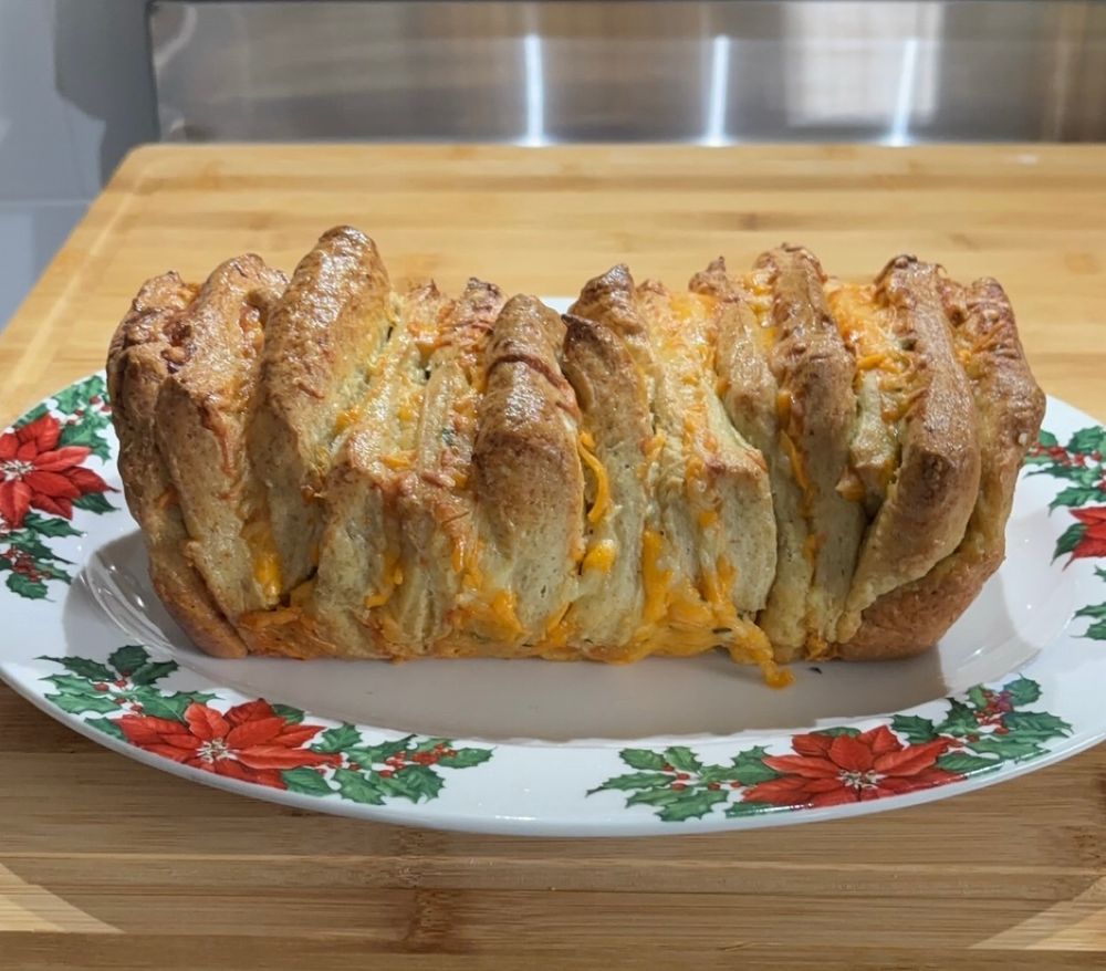 garlic cheesy bread on a platter with poinsettia art on the edges