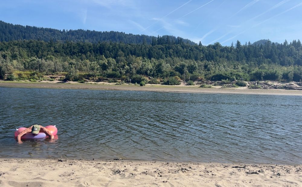 My husband on a pink ring floaty on the river at Rooster Rock
