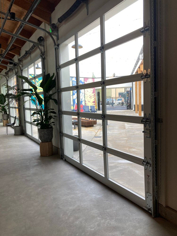 Four bays of roll up doors looking out into a courtyard, it’s all very new concrete.