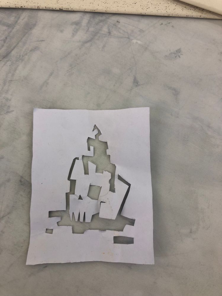 A paper template for an image of a skull with a melting candle on its head. 