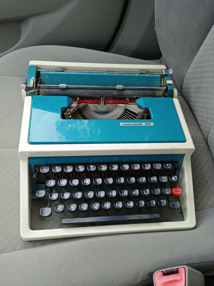 The underwood 315 in question sitting on my passenger seat after sealing the deal

It's a pleasant robins-egg-but-bluer accents with a light cream body and a bright red tab button