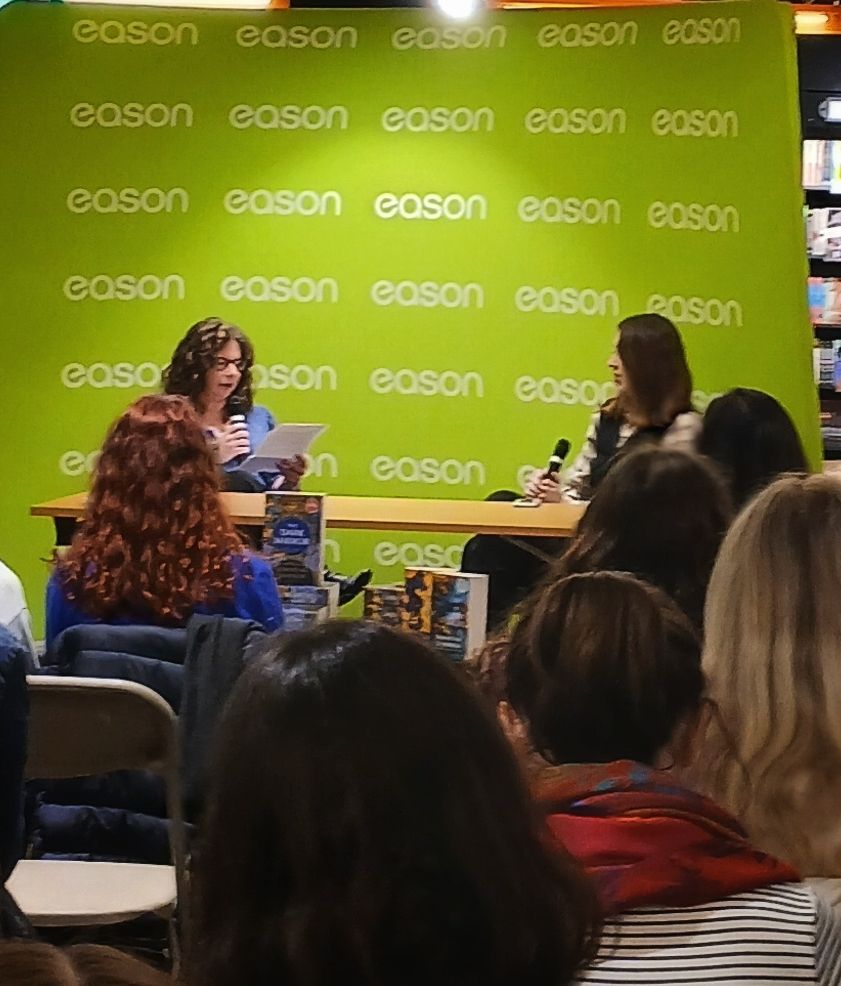 Helen Corcoran and Samantha Shannon sit in an Eason's bookshop discussing Samantha's new novel, The Dark Mirror, in front of an audience. 