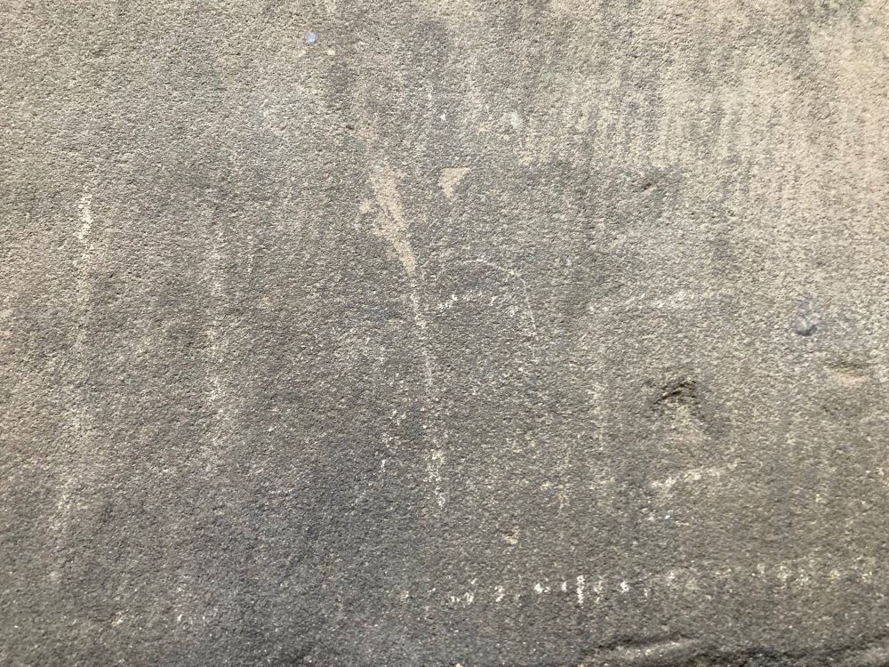 A grey stone in an exterior wall of the University of Glasgow’s main campus, with the very faint image of the chalked word 'Hope'