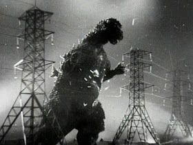 Godzilla crashing through electricity wires between tall pylons