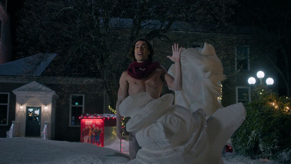 Hot frosty actor standing behind an ice sculpture 