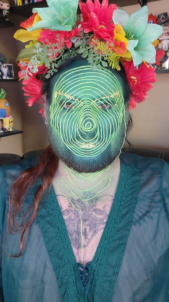 Me with makeup and string on my face  and a flower crown 