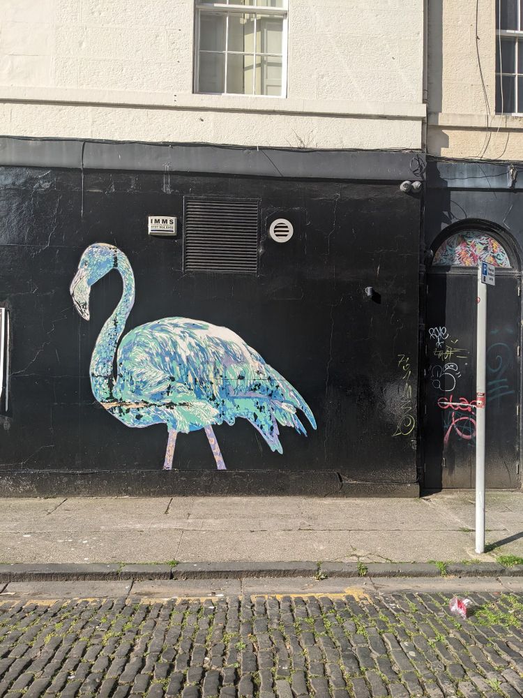 Graffiti of a blue flamingo on a wall in Brighton Street, Edinburgh 